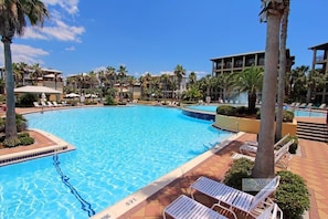 A large pool surrounded by palm trees and lounge chairs, with a clear blue sky above. - Cozy 3BR Beach Home, Pool & Beach Access ~ Blue Lagoon, Seacrest Beach 30A (Panama City Beach)