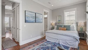 Un dormitorio con cama, mesitas de noche, lámpara de noche, ventilador de techo y ventana con persianas.