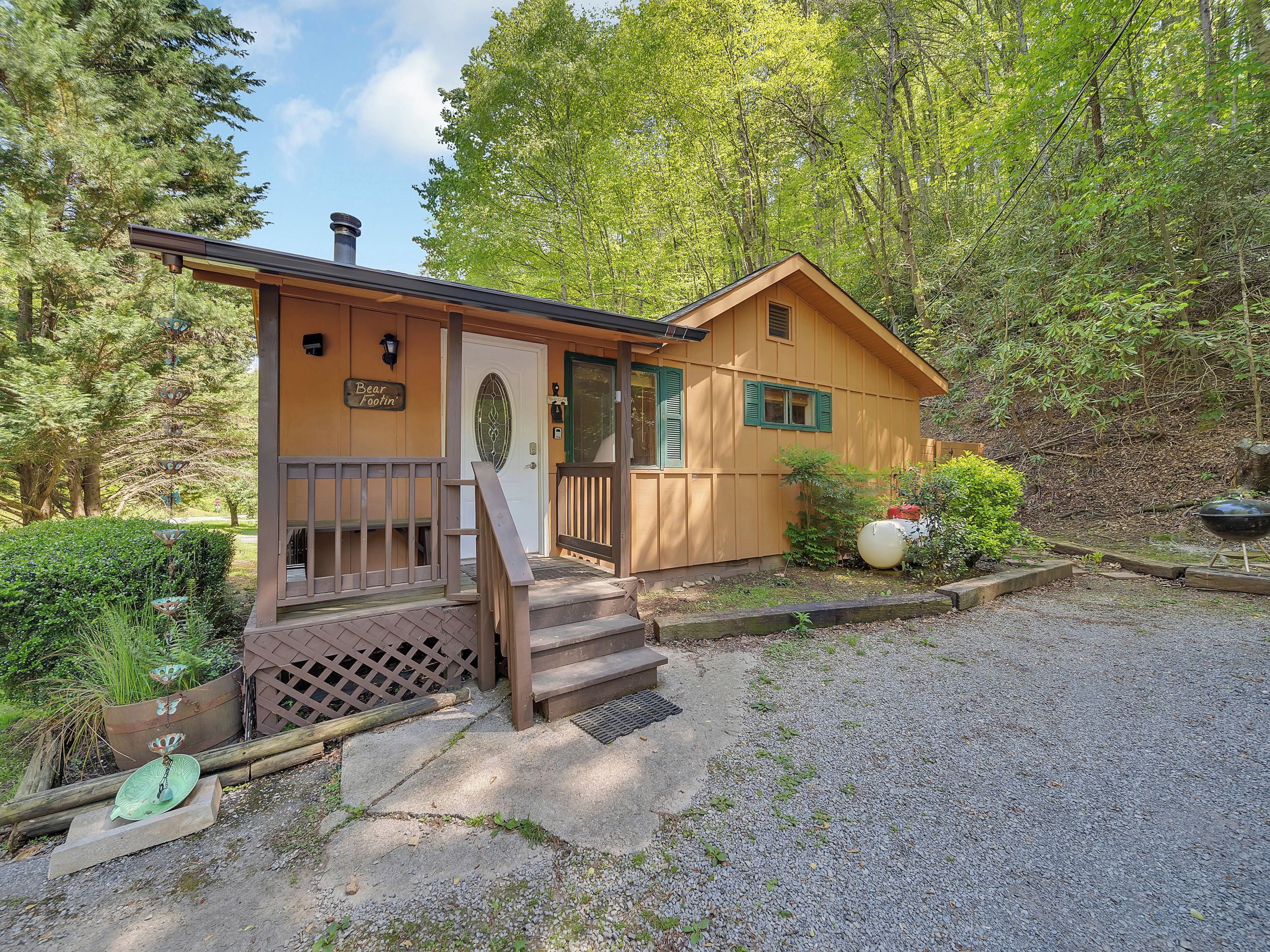 A small wooden cabin with a porch, a door, and a window.