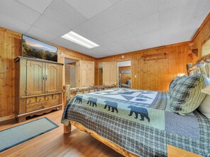 Un dormitorio estilo cabaña con una cama de madera, un armario grande y vistas al exterior.