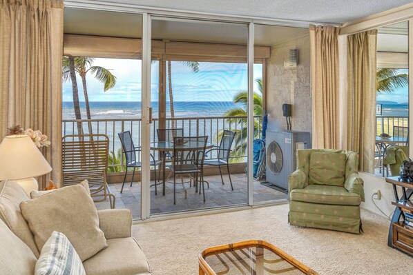 Un balcon avec vue sur l’océan, aménagé avec un canapé, des fauteuils et une table.