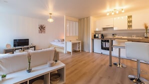 A modern apartment with a living room, a small kitchen, and a dining area. - Studio Cosy - plein coeur de Lannion (Lannion)