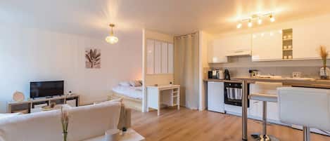 A modern apartment with a living room, a small kitchen, and a dining area.