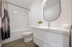 A modern bathroom with a bathtub, toilet, and sink. - Maison Oasis by RVMT (Mont-Blanc)