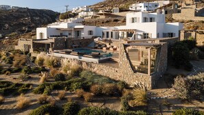 A white villa with a pool, stone walls, and a hillside view. - Ocean whisper villa with amazing view  (mykonos)