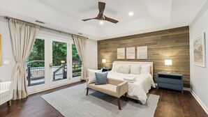 Un dormitorio con cama, mesita de noche y vistas al exterior.