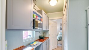 A compact kitchen with a microwave, a small oven, and a wooden countertop. - Retreat w/ Hot Tub & Fenced Yard: Walk to Beach (Port Bolivar)