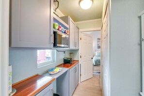 Eine kleine Küche mit Mikrowelle, einem Backofen und einer Holzarbeitsplatte.