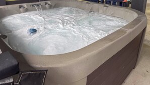 A hot tub with water flowing, surrounded by a concrete structure. - Retreat w/ Hot Tub & Fenced Yard: Walk to Beach (Port Bolivar)
