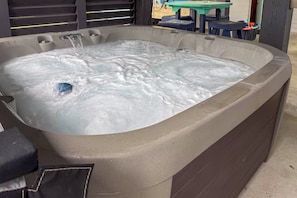 A hot tub with water flowing, surrounded by a concrete structure. - Retreat w/ Hot Tub & Fenced Yard: Walk to Beach (Port Bolivar)