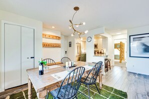 A dining area with a wooden table, black chairs, and a unique chandelier. - Fraser Condo w/ Ski Shuttle & Resort Amenities! (Fraser)