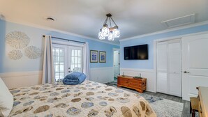 Une chambre à coucher avec un lit, une commode et un téléviseur fixé au mur.