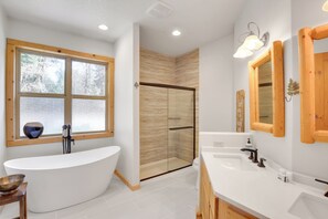 A modern bathroom with a freestanding bathtub, a glass-enclosed shower, and a large window providing natural light. - Peaceful Rhododendron Cabin w/ Fire Pit & Hot Tub! (Rhododendron)