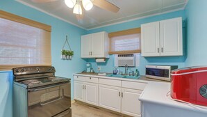 Una cocina equipada con estufa, microondas y refrigerador.