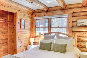A wooden cabin bedroom with a large bed, a window, and a wooden ceiling. - Lakefront Park Rapids Cabin w/ Decks & Boat Dock! (Park Rapids)