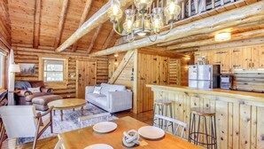A log cabin interior with a dining area, kitchen, and living room. - Lakefront Park Rapids Cabin w/ Decks & Boat Dock! (Park Rapids)