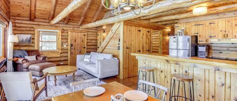 Een vakantiehuisje van hout met een eethoek, keuken en woonkamer.
