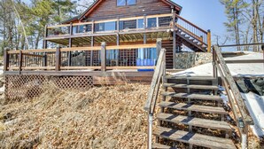 A wooden cabin with a balcony and a staircase leading to the entrance. - Lakefront Park Rapids Cabin w/ Decks & Boat Dock! (Park Rapids)