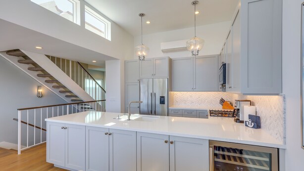 A modern kitchen with a central island, stainless steel appliances, and pendant lighting. - Sleek Oxnard Townhouse w/ Balconies: Walk to Beach (Oxnard)