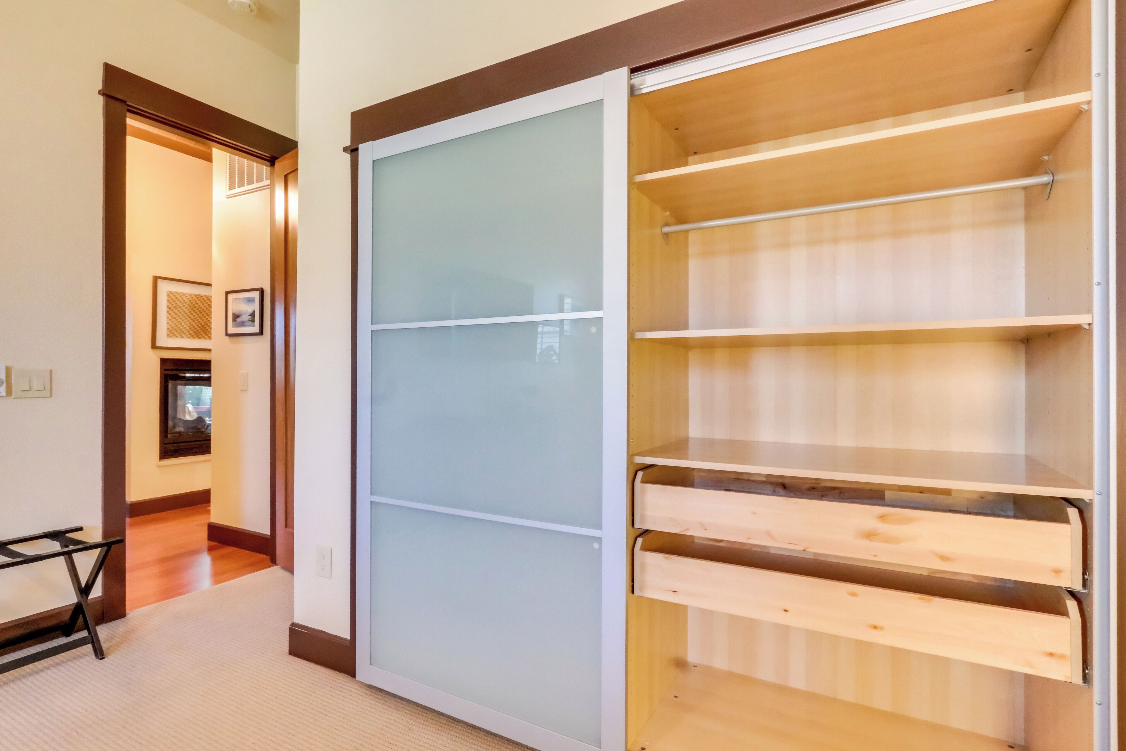 A walk-in closet with sliding doors and multiple shelves.