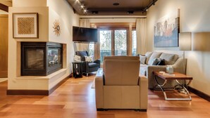 A modern living room with a fireplace, a sofa, a coffee table, and a TV.