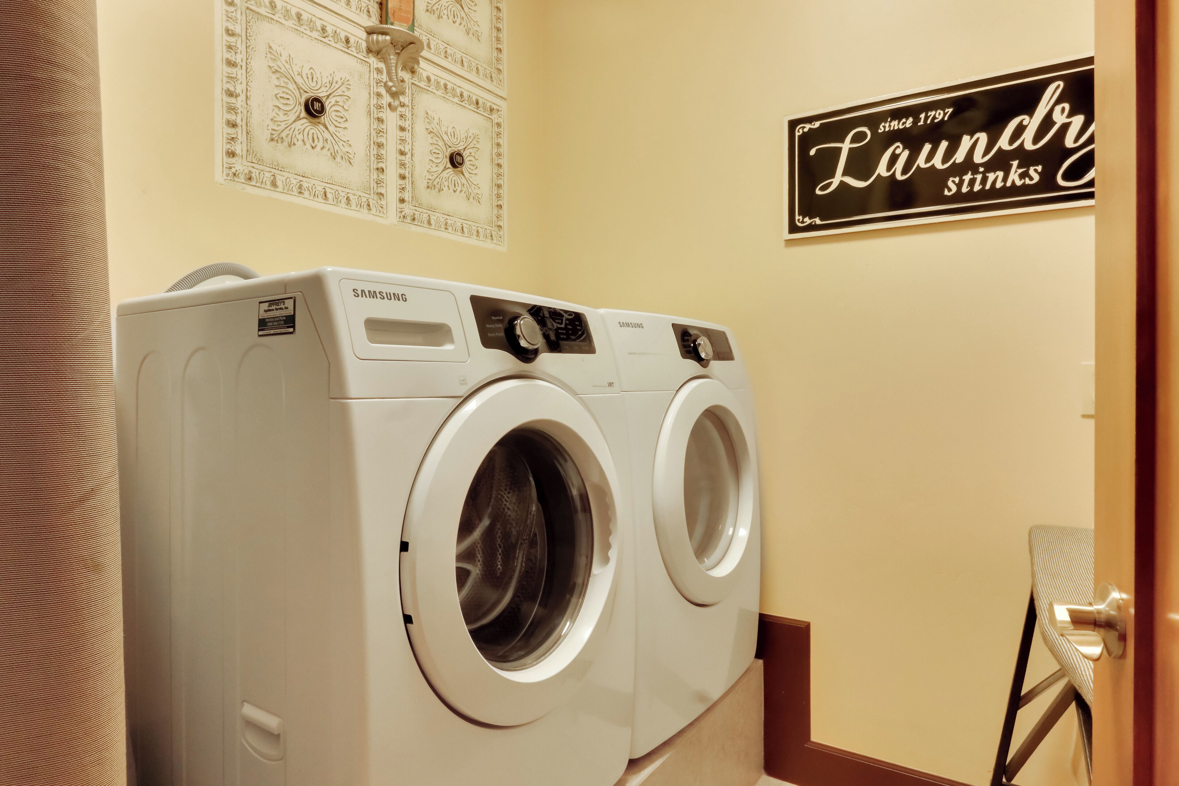 Une buanderie équipée de deux lave-linge Samsung à chargement frontal, de couleur blanche.