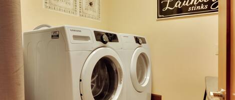 Une buanderie équipée de deux lave-linge Samsung à chargement frontal, de couleur blanche.