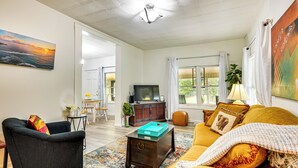 A living room with a sofa, armchair, TV, and a coffee table. - Lakeview Vacation Rental - Walk to Crystal Lake! (Lakeview)
