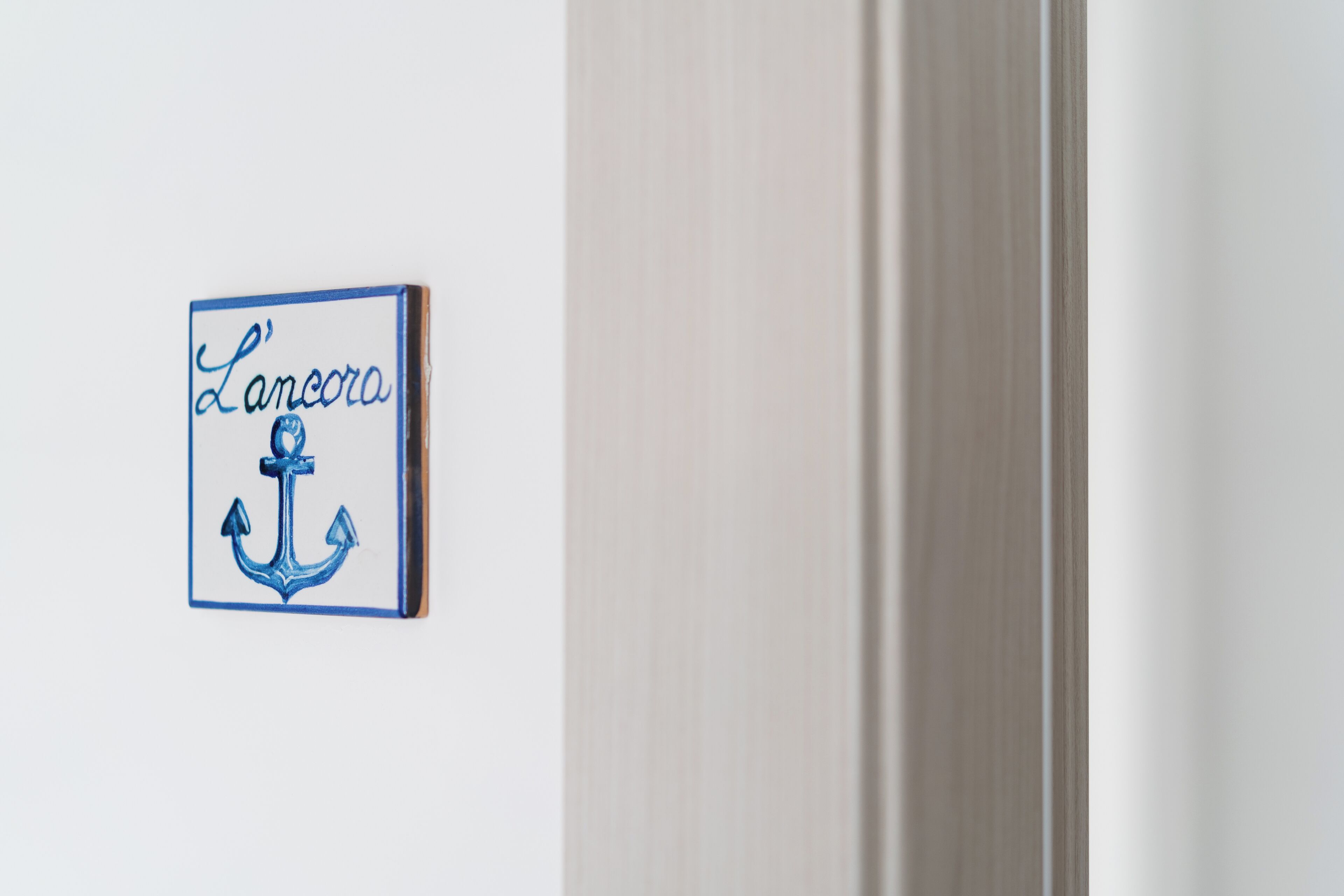 A wall-mounted sign with the name 'Lancora' and an anchor symbol.