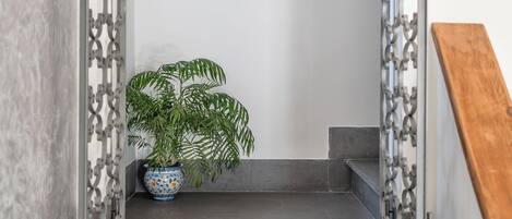 A staircase with a modern design, featuring a potted plant and framed inspirational quotes on the wall.