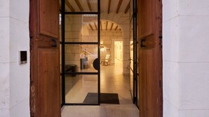 A wooden door with glass panels leading into a room with stone walls and a tiled floor. - Hotel Ca Sa Pagesa (Santa Margalida)