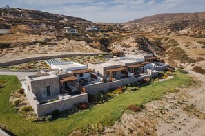 A modern villa with multiple bedrooms, a swimming pool, and a landscaped garden. - Horizon Suites Milos (Milos)