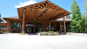 A lodge with a covered entrance, large windows, and a wooden facade.