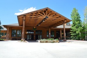 A lodge with a covered entrance, large windows, and a wooden facade.