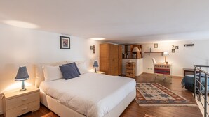A bedroom with a bed, bedside tables, a wardrobe, a desk, and a chair. - Loft Della Rosa by Wonderful Italy (Palermo)