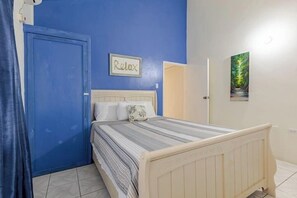 A bedroom with a bed, a blue door, and a 'Relax' sign on the wall. -  The Dream Nest At Csompo Silver Manor (Tower Isle)