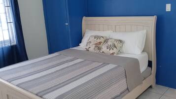 Un dormitorio con una cama, una pared azul y la palabra 'Relax' enmarcada en la pared.
