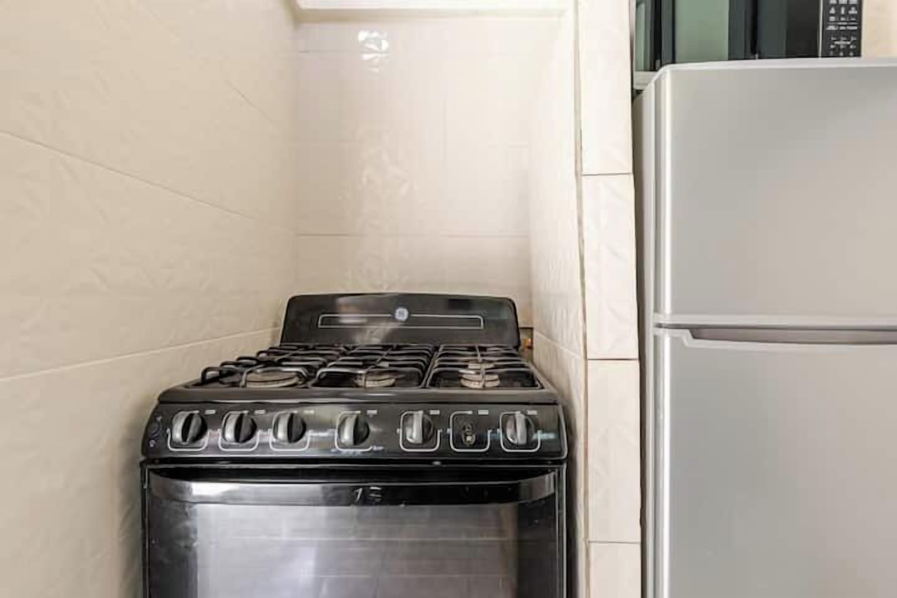 A kitchen with a black stove and a white refrigerator.
