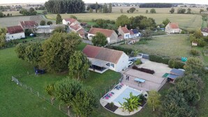 An aerial view of a residential area with houses, a swimming pool, and surrounding greenery. - House 10 People Swimming Pool With Jacuzzi (Boucé)