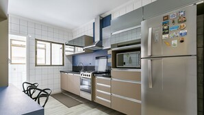 Een moderne keuken met roestvrijstalen apparatuur, een gasfornuis en een koelkast.
