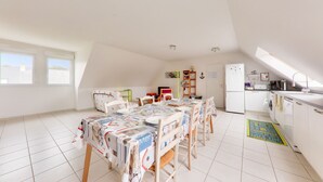 Una cocina amplia con comedor, lavadora y refrigerador.