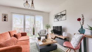 Una sala de estar moderna con sofá, mesa de centro y televisor.