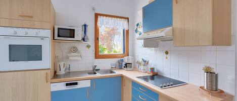 A modern kitchen with a built-in oven, microwave, and dishwasher.