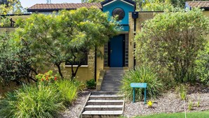 A building with a blue door, a number '1' on the wall, and a sign reading 'SANOPIPER'. - Sandpiper, Hyams Beach, Jervis Bay (Hyams Beach)