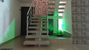 Una escalera moderna con un muro de acento de ladrillo, que conduce a un nivel superior.