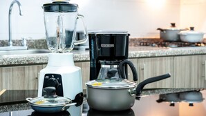 Una cocina con una licuadora, una cafetera y una olla sobre la encimera.