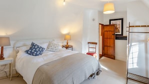 A neatly arranged bedroom with a bed, bedside lamps, a chair, a wardrobe, and a hanging light fixture. - 2 bedroom accommodation in Much Hadham (Much Hadham)