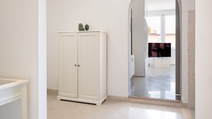 A white wardrobe with a mirror, a tiled floor, and a doorway leading to another room. - Roma per te - One Bedroom Apartment, Sleeps 4 (Rome)