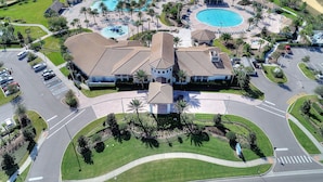 An aerial view of a resort with multiple swimming pools, a central building with a tiled roof, and a parking area. - 6 Bed South Facing Pool Resort and Games Room (Davenport)