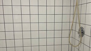 Een badkamer met witte betegelde wanden en een bad.